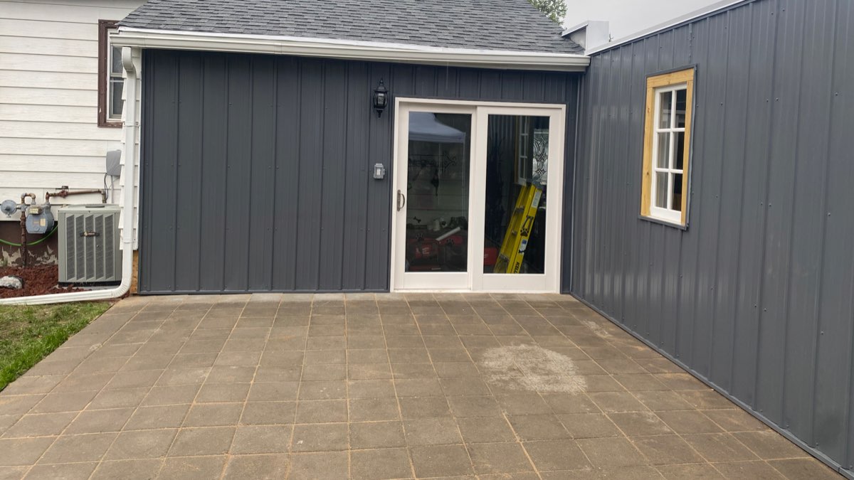 New tile patio and dark siding installed on a home exterior in Enid, Oklahoma