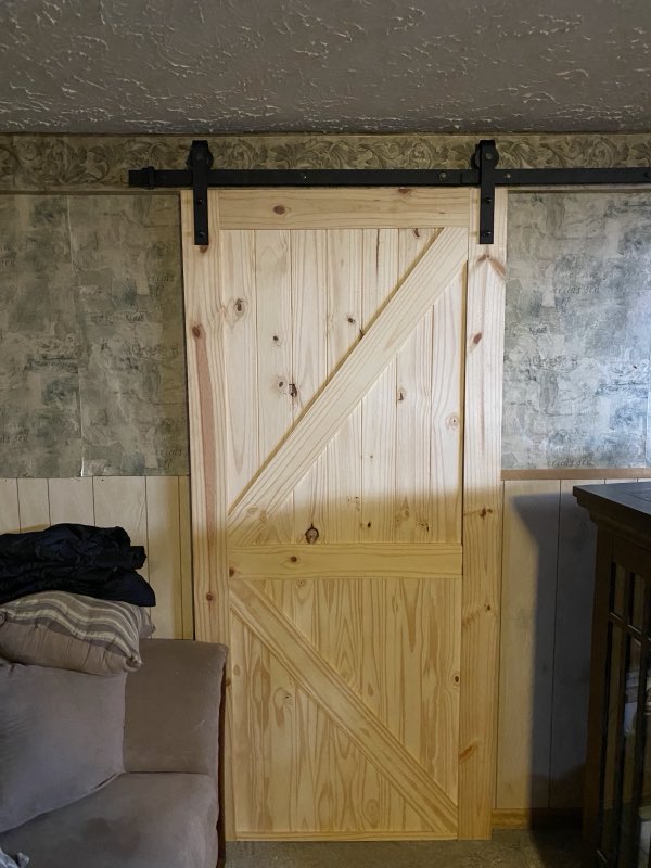 Custom-built sliding wood barn door installed on black rail hardware